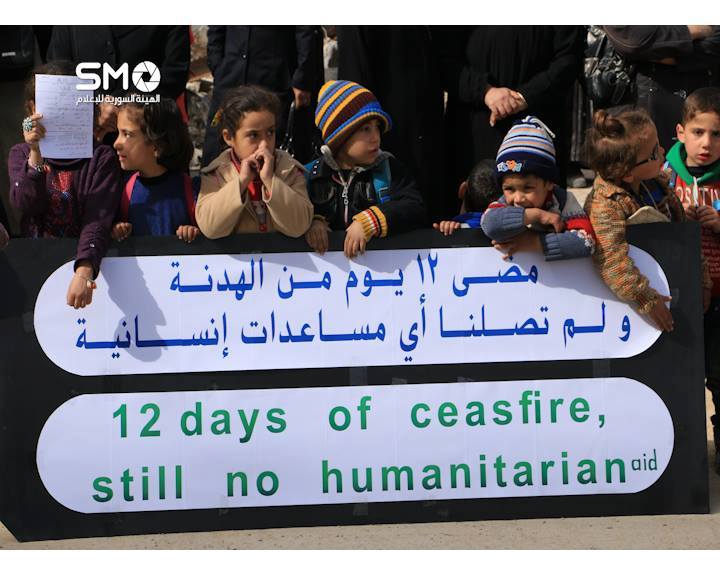 Children hold sign in Daraya protesting the lack of humanitarian aid, despite the ceasefire